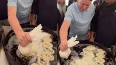As he poured the batter into a large wok of hot oil, people around him cheered and recorded the moment. File Photo.
