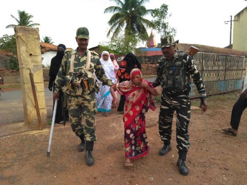 CRPF personnel helping a 90-year-old to reach out to the polling booth