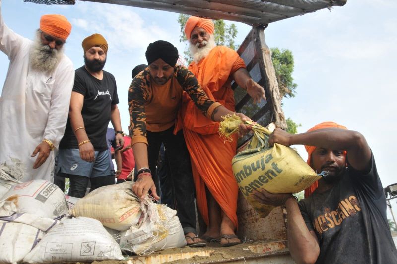 MP Harbhajan Singh's Hands-On Efforts: Assisting in Dhusi Dam Embankment by Lifting Sacks of Soil
